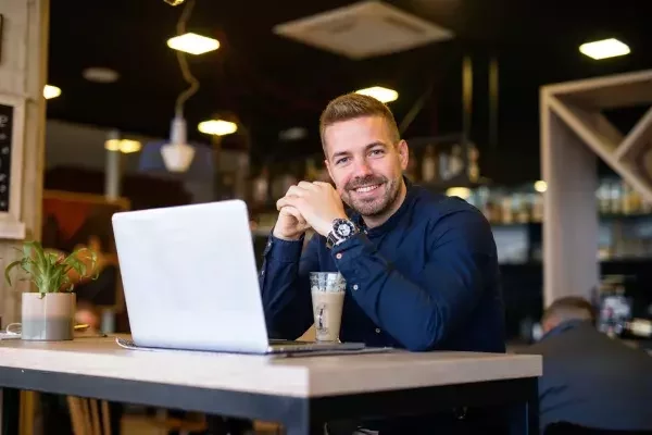 Inhaber sitzt am Laptop und ist glücklich
